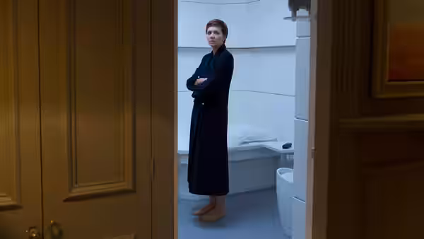 Nessa Stein (Maggie Gyllenhaal) standing barefoot in a bathroom with arms crossed