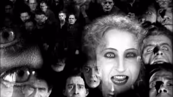 Woman with wild hair surrounded by many staring faces