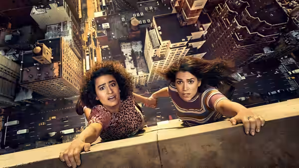 Abbi Abrams (Abbi Jacobson) and Ilana Wexler (Ilana Glazer) leaning over a high ledge above the city
