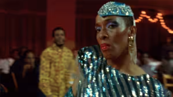 A performer in a sparkling blue outfit at a ballroom event