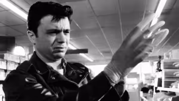 Perry Smith (Robert Blake) examines a gloved hand in a shop