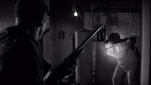 A man with a rifle confronts a crouching figure in a dim basement