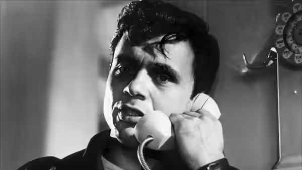 Perry Smith (Robert Blake) speaks on a telephone