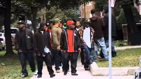 Group of young men walking along a sidewalk in a residential neighborhood