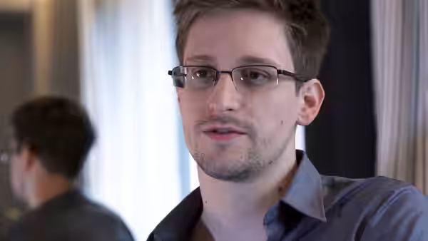Edward Snowden speaking during an interview in a blue shirt