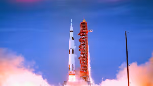 a Saturn V rocket lifts off the launch pad amid clouds of smoke