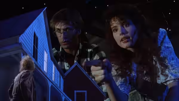 Adam (Alec Baldwin) and Barbara (Geena Davis) looking at a miniature house