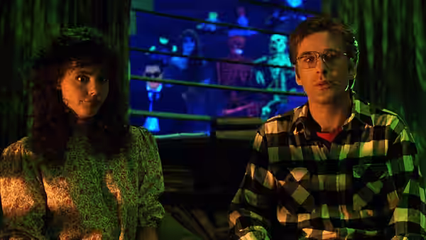Adam (Alec Baldwin) and Barbara (Geena Davis) standing side by side indoors