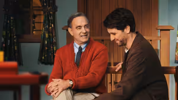 Fred Rogers (Tom Hanks) sits beside Lloyd Vogel (Matthew Rhys), who looks down