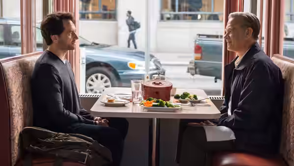 Lloyd Vogel (Matthew Rhys) and Fred Rogers (Tom Hanks) sit across a restaurant table