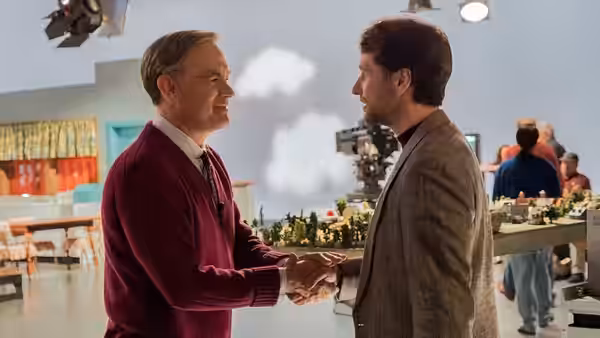 Fred Rogers (Tom Hanks) shakes hands with Lloyd Vogel (Matthew Rhys) on the studio set
