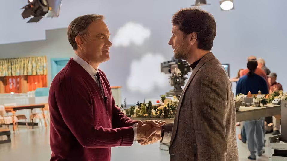 Fred Rogers (Tom Hanks) shakes hands with Lloyd Vogel (Matthew Rhys) on the studio set
