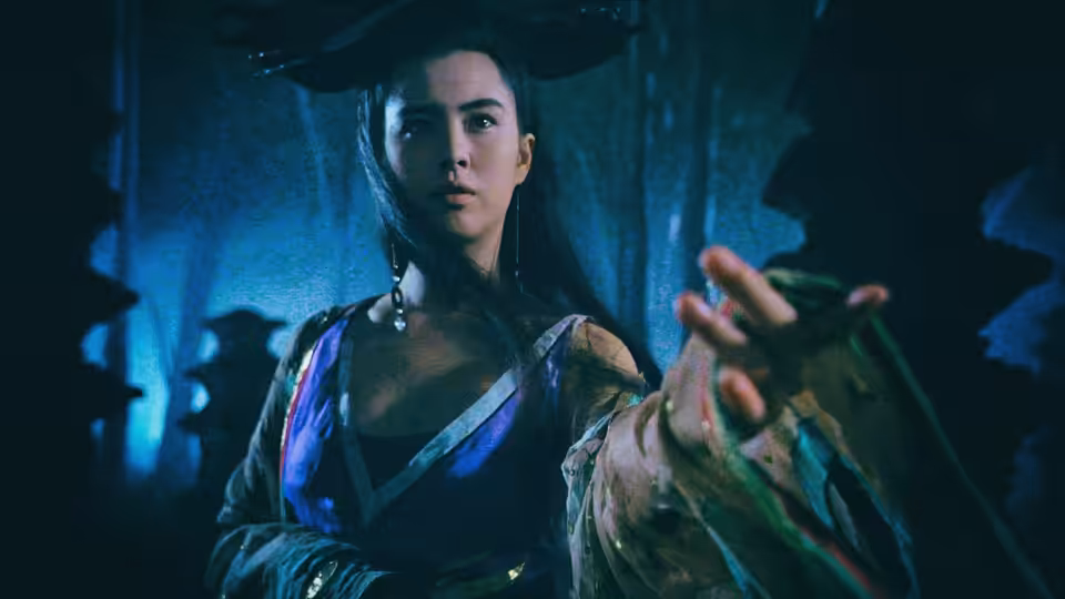 Lip Siu Sin (Joey Wong) reaches out in a shadowy, blue-lit room