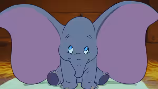 Dumbo sitting with large ears spread and a sad expression