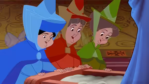 Three fairies in blue red and green lean forward peering into a box