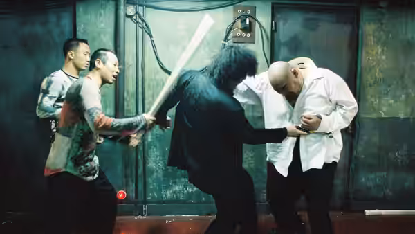 Oh Dae-su (Choi Min-sik) swinging a long weapon at two men in a hallway