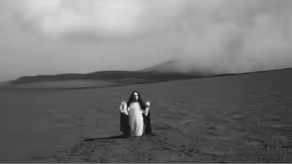 Cristo stands between two figures on an empty plain