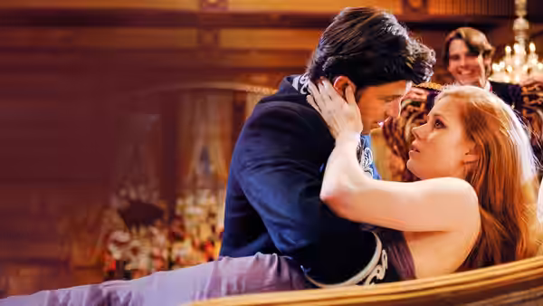 Giselle and Robert embrace closely in a dimly lit ornate room