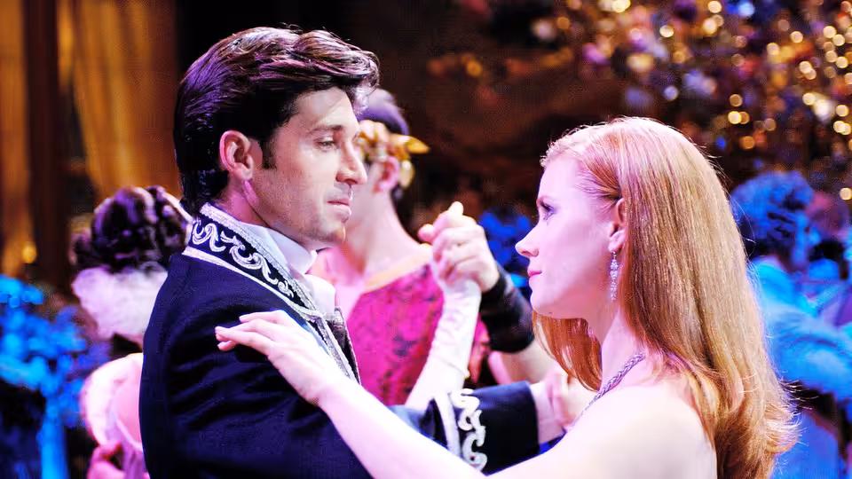 Giselle and Robert dance closely together in a decorated ballroom