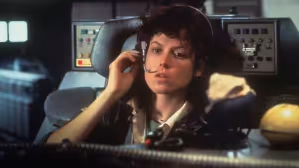 Ripley (Sigourney Weaver) speaking into a headset in the command chair