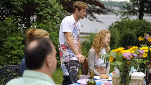 Howie (Aaron Eckhart) standing beside Becca (Nicole Kidman) at an outdoor table