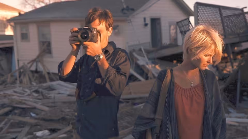 Andrew (Scoot McNairy) photographing with Samantha (Whitney Able) in a ruined neighborhood