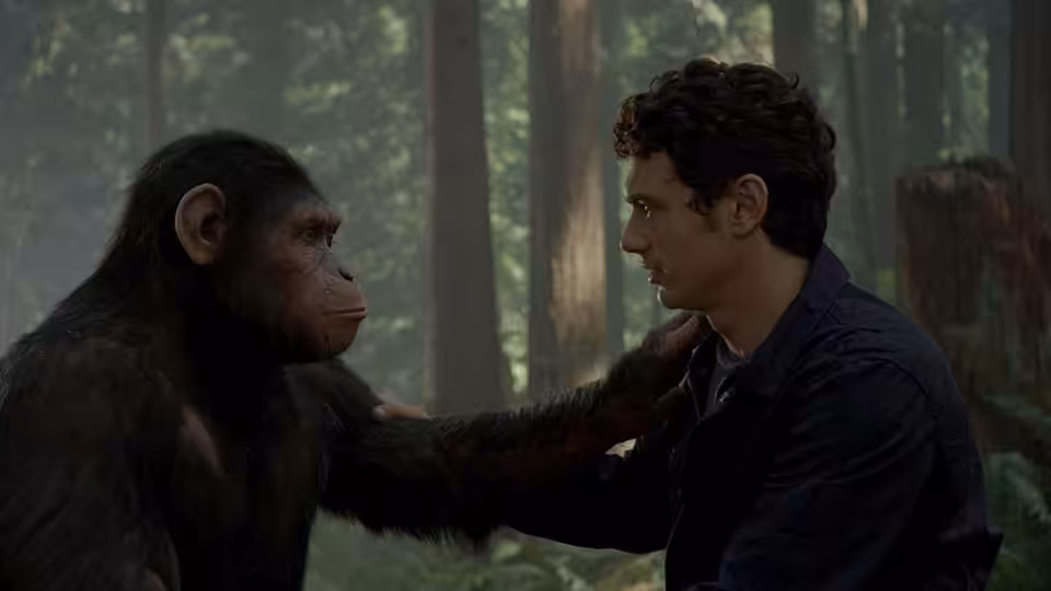Caesar (Andy Serkis) placing a hand on Will Rodman's (James Franco) shoulder in the forest