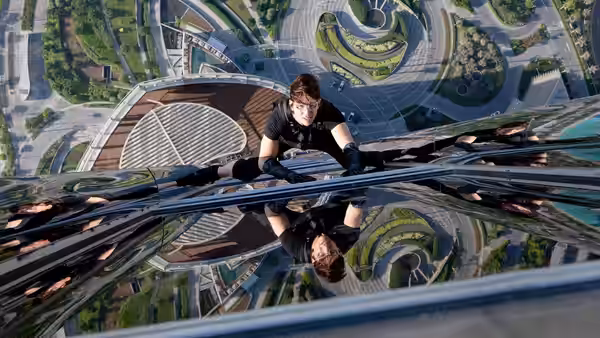 Ethan Hunt (Tom Cruise) climbing the glass exterior of a skyscraper