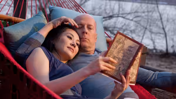 Old Joe (Bruce Willis) and his wife (Xu Qing) resting in a hammock