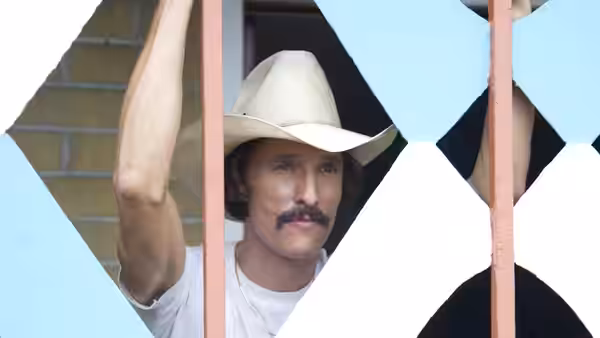 Ron Woodroof (Matthew McConaughey) grips bars of blue and white gate