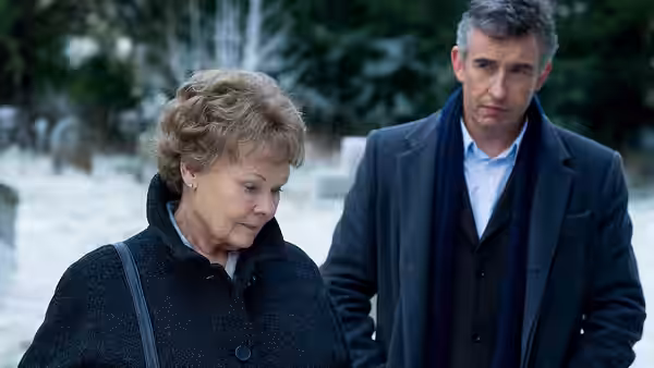 Philomena (Judi Dench) and Martin Sixsmith (Steve Coogan) stand in a snowy graveyard