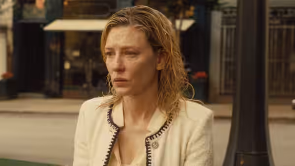 Jasmine (Cate Blanchett) sitting on a street looking distressed