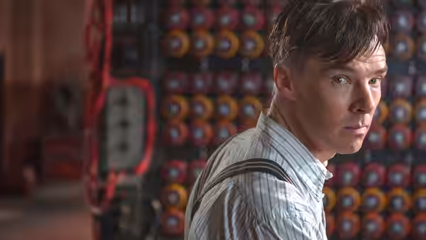 Alan Turing (Benedict Cumberbatch) glancing sideways near spinning rotors