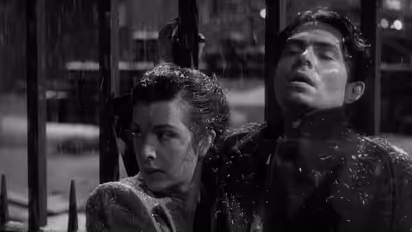 Kathleen Sullivan sits beside the injured Johnny McQueen indoors