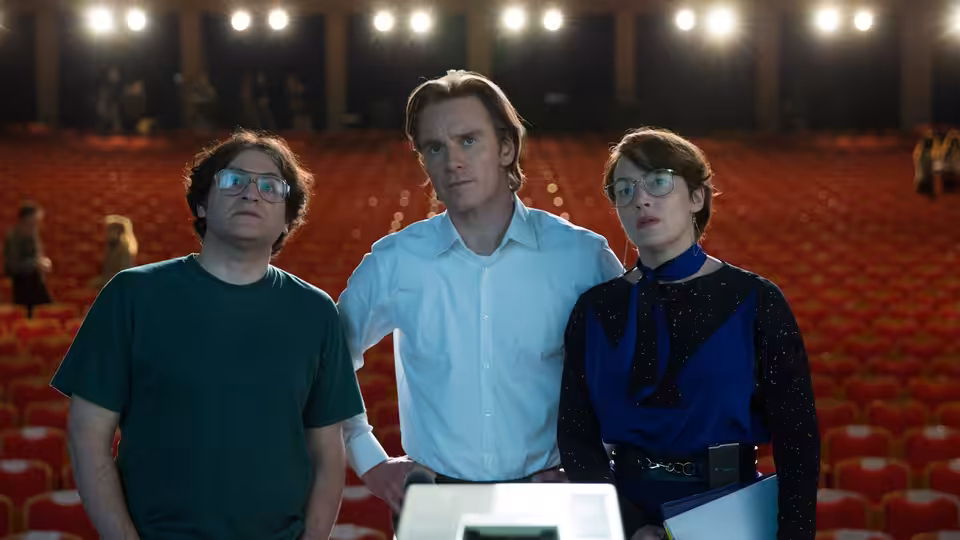 Steve Wozniak (Seth Rogen) Steve Jobs (Michael Fassbender) and Joanna Hoffman (Kate Winslet) stand in an auditorium