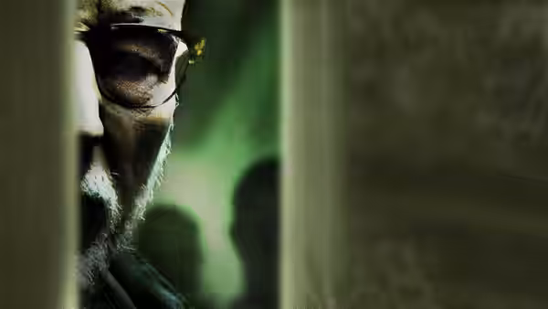 Darcy (Patrick Stewart) peers around a corner wearing dark sunglasses