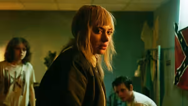Amber (Imogen Poots) glances back over her shoulder inside a dim cluttered room