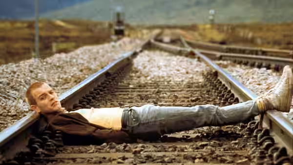Renton (Ewan McGregor) lying on railway tracks between the rails