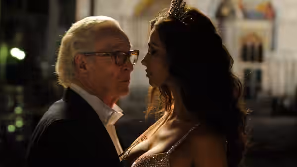 Elderly man and woman with a tiara facing each other at night