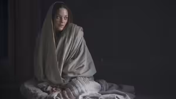 Lady Macbeth (Marion Cotillard) sitting on the floor wrapped in white cloth