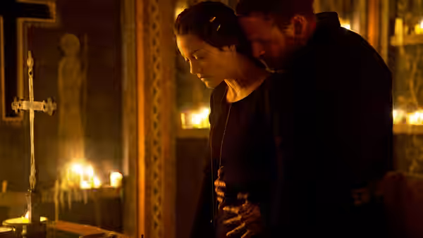 Macbeth (Michael Fassbender) embracing Lady Macbeth (Marion Cotillard) in a candlelit church