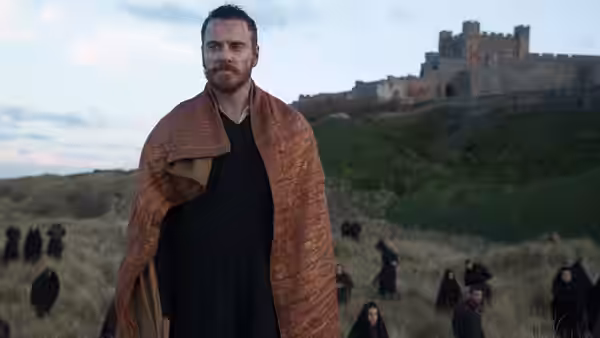 Macbeth (Michael Fassbender) standing on a hillside overlooking a distant castle