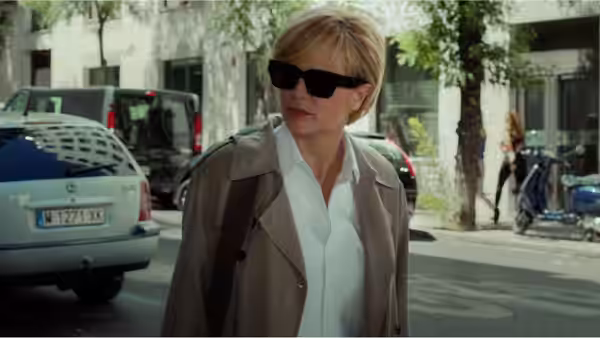 Julieta (Emma Suárez) walks on a city street in sunglasses and trench coat