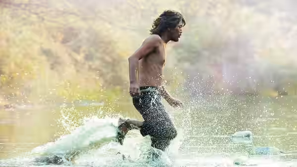 Mr. Kim (Jung Jae-young) runs through shallow water on the riverbank