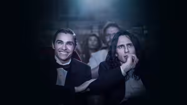 Greg (Dave Franco) and Tommy (James Franco) seated together in a dark theater