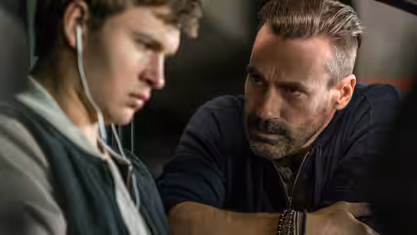 Baby (Ansel Elgort) listens as Doc (Kevin Spacey) speaks in a car