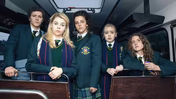 Group of teenagers in uniforms riding inside the back of a van