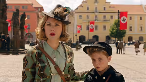 Rosie (Scarlett Johansson) stands with Jojo in a square lined with Nazi flags