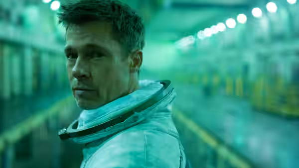 Roy McBride (Brad Pitt) looks back in a green-lit industrial corridor