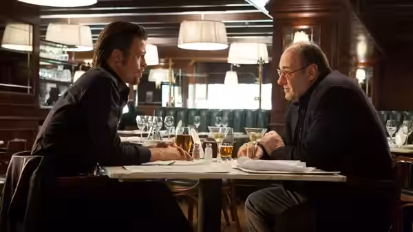 Jackie Cogan (Brad Pitt) and Mickey (James Gandolfini) talking over drinks at a restaurant table